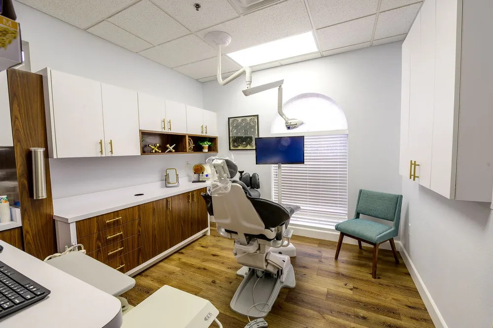 Clean dental exam room with a blue dental chair at Joshua M. Ignatowicz DMD and Associates