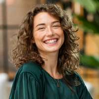 Young woman with curly hair smiling after cosmetic dental treatment