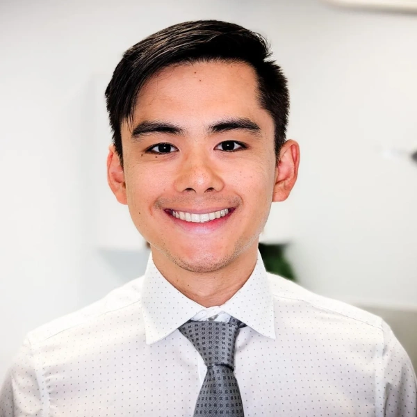 Dr. Nathan Chen smiling in a professional dental office setting